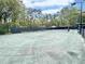 Green tennis court surrounded by tall trees and fencing, provides a private and scenic setting at 1551 Spinnaker Dr. # 5913, North Myrtle Beach, SC 29582