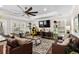 Inviting living room with tray ceilings, ceiling fan, plush seating, and entertainment center at 1616 S Ocean Blvd., North Myrtle Beach, SC 29582