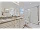 Bathroom featuring double sinks with granite countertop, tiled floors, and glass-enclosed shower at 175 Summer Wind Loop, Murrells Inlet, SC 29576