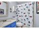 Cozy bathroom featuring blue vanity with white marble top and fun patterned shower curtain at 1912 Goose Creek Rd. Sw # 4302, Ocean Isle Beach, NC 28469