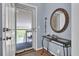 Inviting entryway featuring console table, round mirror, and screen door leading to balcony at 1912 Goose Creek Rd. Sw # 4302, Ocean Isle Beach, NC 28469