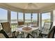 View of the waterfront from the sunroom with a round table and multiple chairs at 1912 Goose Creek Rd. Sw # 4302, Ocean Isle Beach, NC 28469