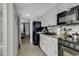 Efficient kitchen with black appliances, white cabinetry, and tile flooring at 2001 S Ocean Blvd. # 721, Myrtle Beach, SC 29577