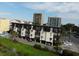 Three-story condo building with black trim, white siding, balconies, covered parking, and beautifully landscaped grounds at 201 76Th Ave. N # E3, Myrtle Beach, SC 29577