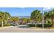 Inviting condo exterior with palm trees, parking, and a well-maintained brick facade under a sunny sky at 210 Double Eagle Dr. # B-2, Surfside Beach, SC 29575