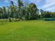 Expansive green backyard featuring a dark metal fence and lush surrounding trees near the water at 2230 Ainsley Dr., Little River, SC 29566