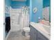 The renovated bathroom boasts a tub and shower combo, complimented by stylish blue walls at 2230 Ainsley Dr., Little River, SC 29566