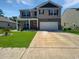 Charming two-story home featuring a well-manicured lawn, a red door, and a two car garage at 2230 Ainsley Dr., Little River, SC 29566