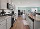 Bright kitchen featuring gray cabinets, stainless appliances, granite countertops, and an island with sink at 2230 Ainsley Dr., Little River, SC 29566