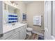 This bathroom has white cabinets and a mirror over a vanity with a blue-striped shower curtain at 2405 Duffy St., North Myrtle Beach, SC 29582