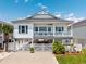 Charming raised beach house with white siding, gray shutters, and a spacious front porch at 2405 Duffy St., North Myrtle Beach, SC 29582