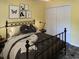 Staged bedroom featuring iron bed frame, closet, and yellow colored walls at 251 Egret Run Ln. # 1122, Pawleys Island, SC 29585