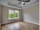 Bedroom with tray ceiling, large window, and hardwood floors, providing ample natural light at 2599 Woodcreek Ln., Conway, SC 29527