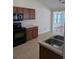 Functional kitchen featuring black appliances, dark cabinets, and a double stainless steel sink at 281 Palmetto Glen Dr., Myrtle Beach, SC 29588