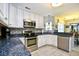 Spacious kitchen featuring stainless steel appliances, a breakfast bar, and granite countertops with tile flooring at 3105 Robyn Ct., Little River, SC 29566