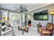 Bright living room with tile floors, ceiling fan, a glass table, a gray couch, and a TV on the wall at 3105 Robyn Ct., Little River, SC 29566