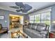 Living room with tile flooring, ceiling fan, a glass table, and a gray couch that leads to the kitchen at 3105 Robyn Ct., Little River, SC 29566