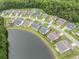 Aerial view of a community with well-maintained homes, lush greenery, and a beautiful lake at 364 Palm Lakes Blvd., Little River, SC 29566