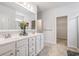 Bright bathroom with double sinks, white cabinetry, and an adjacent walk-in closet at 364 Palm Lakes Blvd., Little River, SC 29566