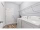Functional laundry room featuring a washer and dryer, overhead shelving, and a convenient utility door at 364 Palm Lakes Blvd., Little River, SC 29566