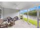 Enclosed patio with views of a lake, featuring wicker furniture and stone flooring for outdoor relaxation at 364 Palm Lakes Blvd., Little River, SC 29566