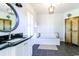 Bright bathroom featuring black tile floors, a soaking tub, and a round mirror above a black countertop at 3718 Highway 931, Conway, SC 29526