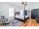 Bedroom with hardwood floors, four poster bed, and black closet doors at 3718 Highway 931, Conway, SC 29526