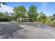 Exterior view with tree shadows over parking spaces and the property behind at 415 Ocean Creek Dr. # 2388, Myrtle Beach, SC 29572