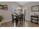 Well-lit dining area featuring dark wood floors, a black table, matching chairs, and neutral paint at 4319 Grande Harbour Blvd., Little River, SC 29566