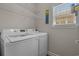 A well-lit laundry room with modern white washer and dryer units and a window for natural light at 4319 Grande Harbour Blvd., Little River, SC 29566