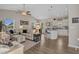 Open-concept living room featuring a vaulted ceiling, fan, wood floors, and a kitchen with white cabinetry at 4319 Grande Harbour Blvd., Little River, SC 29566