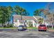 Exterior of a two-story condo featuring a parking lot in the foreground and mature trees in the background at 4486 Little River Inn Ln. # 2106, Little River, SC 29566