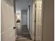 Hallway leading to bedroom and bathroom showcasing wood plank flooring and neutral wall paint at 45 Woodhaven Dr. # D, Murrells Inlet, SC 29576