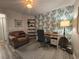 Home office boasts palm leaf wallpaper, modern shelves and lighting and a cozy chair for relaxing at 45 Woodhaven Dr. # D, Murrells Inlet, SC 29576
