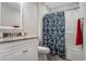 Bright bathroom featuring a granite vanity, ample lighting, and a shower tub combination with a blue patterned curtain at 4853 Meadowsweet Dr. # 1805, Myrtle Beach, SC 29579