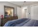This well-lit bedroom features a wooden dresser and a view of the closet and bathroom at 4853 Meadowsweet Dr. # 1805, Myrtle Beach, SC 29579