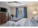 Bedroom features a window view of a balcony, a ceiling fan, and a dark wooden dresser at 4853 Meadowsweet Dr. # 1805, Myrtle Beach, SC 29579