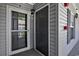 Condo entrance with a storm door and a solid door with gray siding, plus a mail box at 4853 Meadowsweet Dr. # 1805, Myrtle Beach, SC 29579