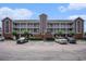 Condo building exterior with balconies and parking in front showing blue sky with white clouds at 4853 Meadowsweet Dr. # 1805, Myrtle Beach, SC 29579