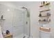 Bright bathroom featuring a glass enclosed shower with subway tile and decorative shelving near the toilet at 515 River Rd., Conway, SC 29526