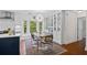 Cozy dining area features a modern chandelier, bay window, glass display cabinets, and an open design to the kitchen at 515 River Rd., Conway, SC 29526