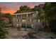Two-story home with grey siding, green shutters, two-car garage, and landscaped front yard at dusk at 515 River Rd., Conway, SC 29526