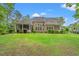 Back exterior view showing a large yard with lush green grass at 528 Chamberlin Rd., Myrtle Beach, SC 29588