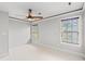 Spacious bedroom featuring carpeted floors, neutral walls, and a fan and two windows at 528 Chamberlin Rd., Myrtle Beach, SC 29588