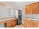Functional laundry room featuring wooden cabinets, granite counters, stacked washer/dryer, and sink at 528 Chamberlin Rd., Myrtle Beach, SC 29588