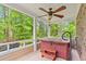 Relaxing covered porch featuring a hot tub and ceiling fan, with a wooded view at 528 Chamberlin Rd., Myrtle Beach, SC 29588