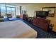 Comfortable bedroom featuring two TVs, dresser, desk, and access to a private balcony with ocean views at 5300 N Ocean Blvd. # 306, Myrtle Beach, SC 29577