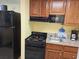 Galley kitchen featuring wooden cabinets, black appliances, and laminate counters at 5300 N Ocean Blvd. # 306, Myrtle Beach, SC 29577