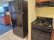 Efficiency kitchen featuring a black refrigerator, black electric range, and tile flooring at 5300 N Ocean Blvd. # 306, Myrtle Beach, SC 29577
