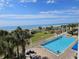 Beautiful view of beach and ocean, with palm trees, playground, and a pool in the foreground at 5300 N Ocean Blvd. # 306, Myrtle Beach, SC 29577